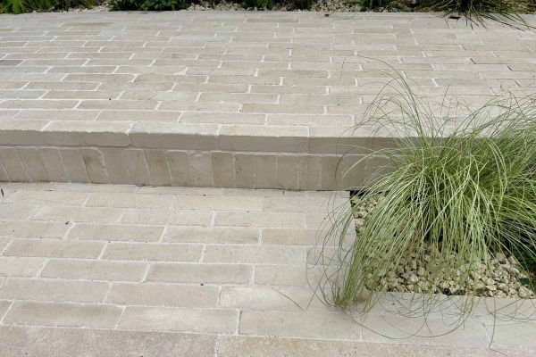 11 Beige sandstone patio bricks laid in 6 rows of 1 or 2 pavers on a dark background. Free UK delivery available.***
