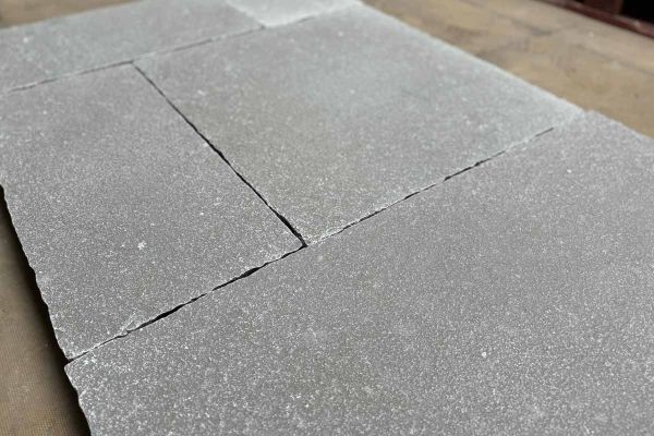Close up rendered image of Antique Grey Limestone paving showing its natural texture and hand-cut edges.***
