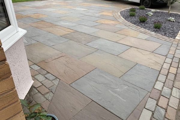 Driveway paved in Raj Green Indian Sandstone 900x600, showing natural blends of browns, greys and green tones with a riven texture.***
